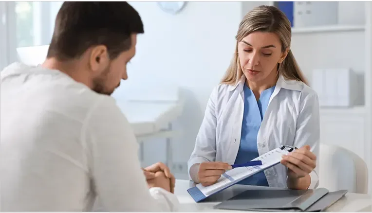 doctor showing man results on clipboard