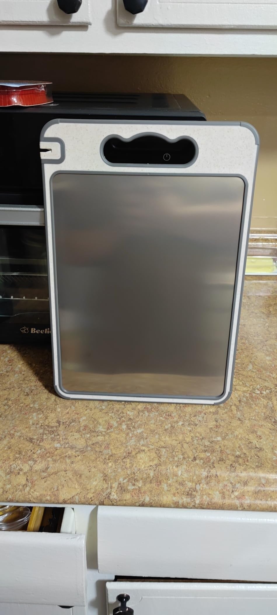 TIBO cutting board photographed by a verified Amazon customer, standing upright on a kitchen counter
